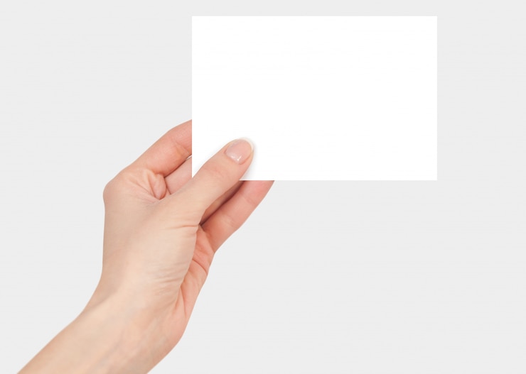 Photo women's fingers holding a blank white card