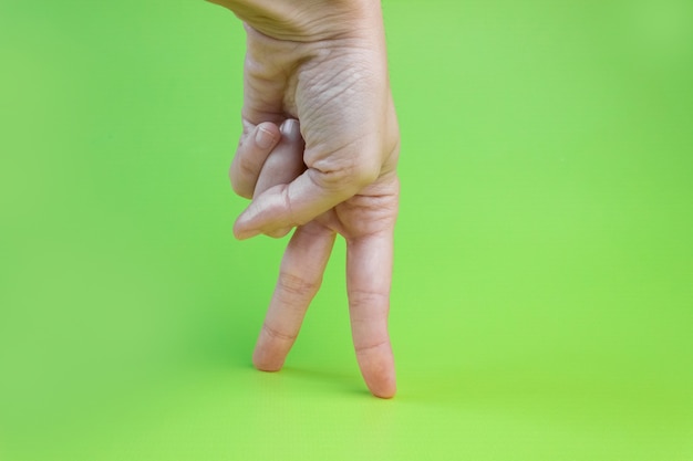 Women's fingers walking on a green background.