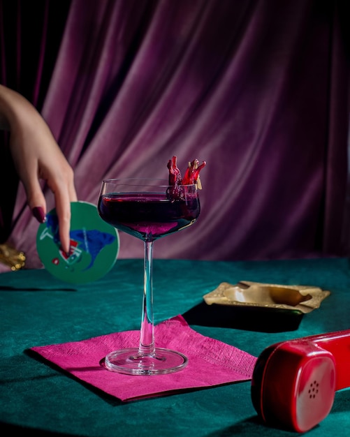 Women's hand and cocktail on a velvet background