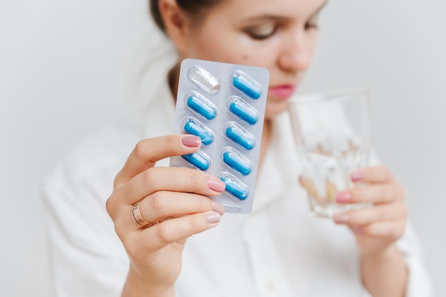파란색 캡슐이 있는 알약 물집이 있는 여성의 손. 의료 보험, 의료 개념