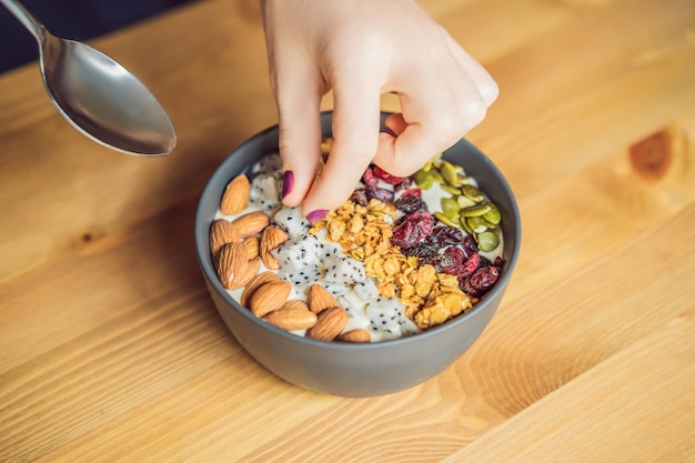 Women's hands are preparing a smoothie bowl