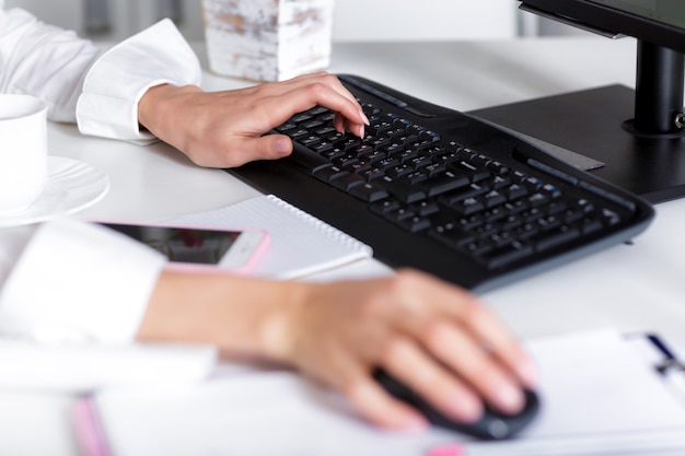 Women's hands are typing on  laptop's keyboard.