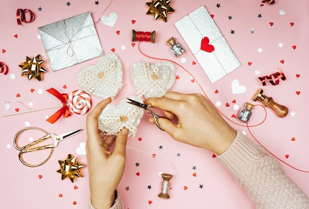 Photo women's hands decorate crafts in the shape of a heart