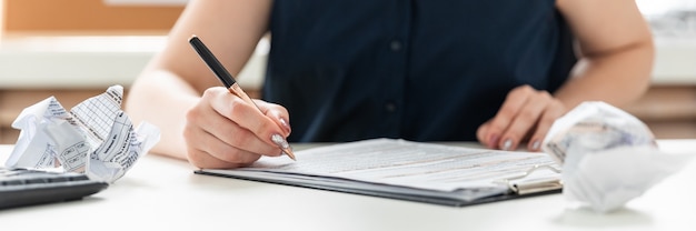 Women's hands fill out a questionnaire.