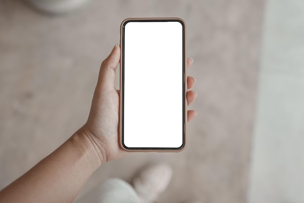 テクノロジーコンセプトの携帯電話の空白のコピースペーススクリーンスマートフォンを保持している女性の手