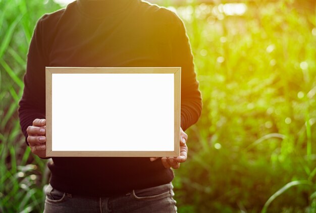 Women's hands holding white blank advertisement card with copy space.