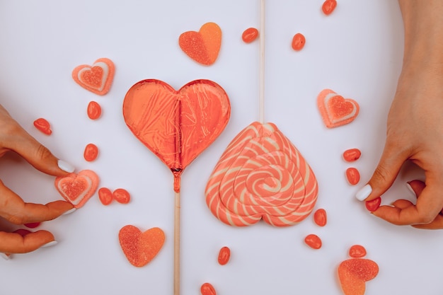 Le mani delle donne conservano le caramelle a forma di cuori