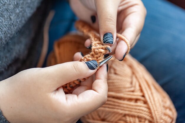 Le mani delle donne sono lavorate a maglia in lana colorata. maglieria a mano