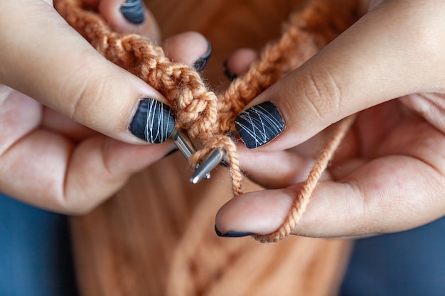 Women's hands knit from colorful wool. Hand knitting