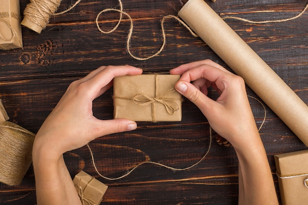 Women's hands making a gift of craft paper.