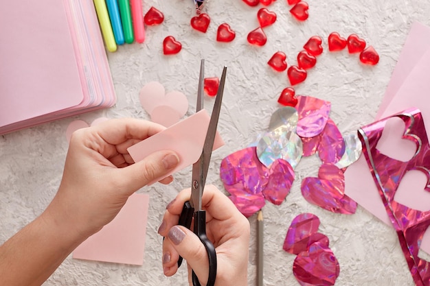 Women's hands making valentine's day cards