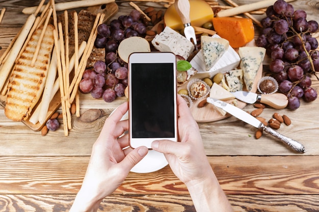 写真 スマートフォンで女性の手が食べ物の写真を撮る