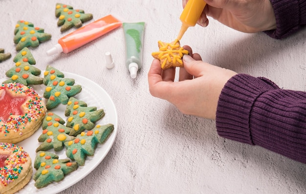 Women's hands paint Christmas gingerbread Preparation for the celebration of Christmas