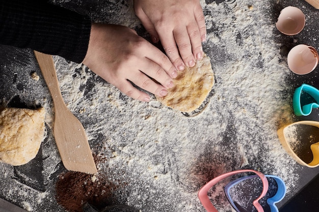 Women's hands prepare cookies for Valentine's day