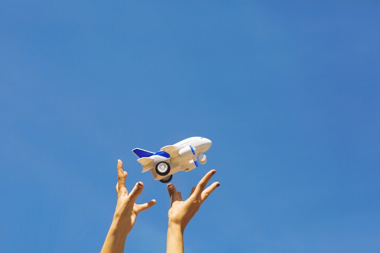 Photo 女性の手は白と青の子供たちの飛行機を投げます。