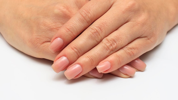 Women's hands with transparent nail polish closeup The concept of care for the skin of the hands and nails