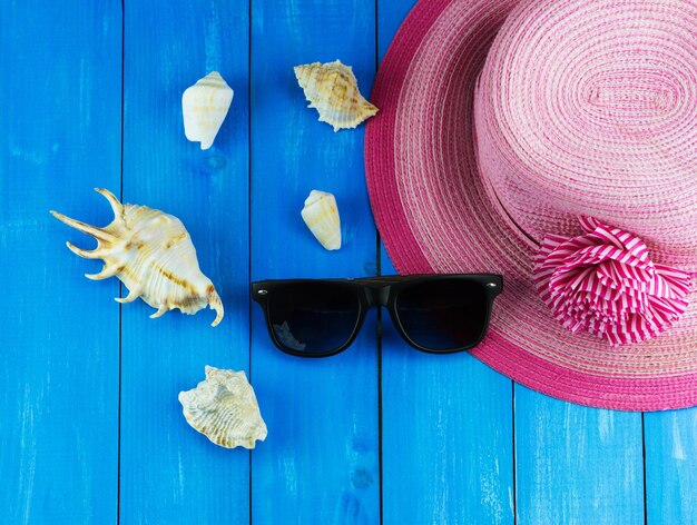 Foto cappello da donna con occhiali da sole e conchiglie