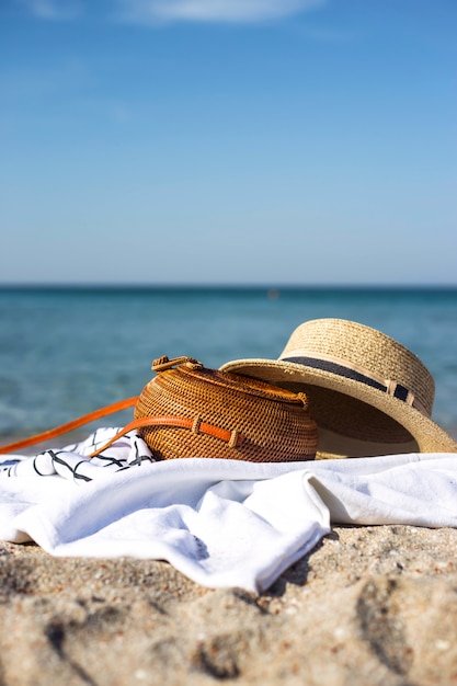 Women's modern round woven bag on the white flooring on the beach