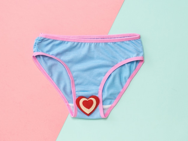 Women's panties in blue color with red heart. Women's underwear. Flat lay.