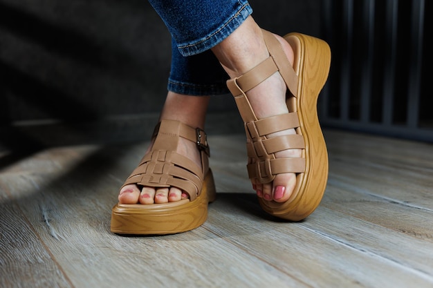 Women's sandals Female feet closeup in casual brown sandals Collection of summer women's sandals