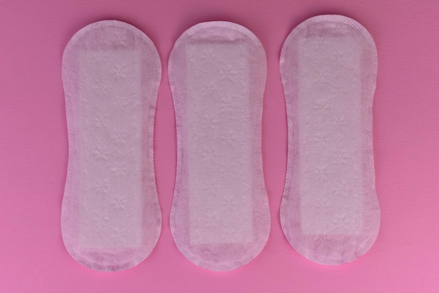 Women's sanitary pads on a pink background.