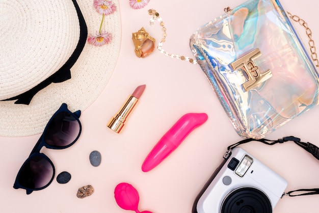 Photo women's set of adult toys, camera, hat, glasses and top view on a light table.