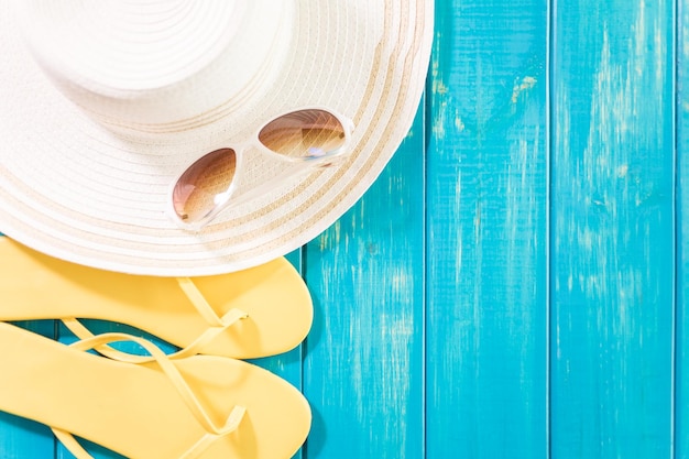 Women's sun hat with flip flops and sunglasses.