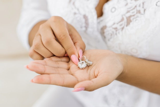 Women's wedding jewelry in the hands of the bride, selective focus