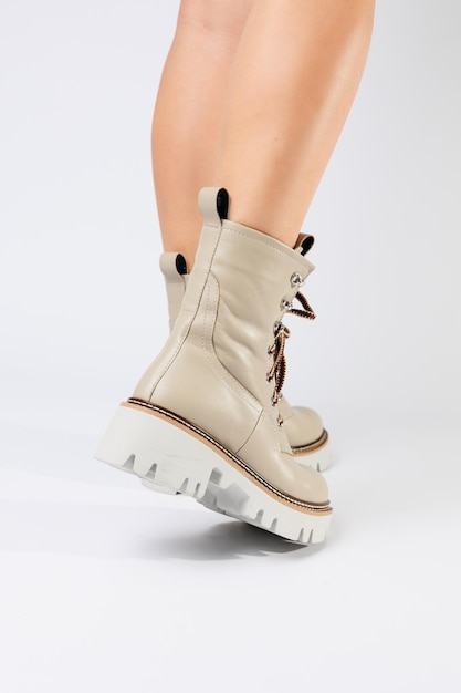 Women's white spring boots made of genuine leather are worn on a woman's leg New collection of women's boots 2022