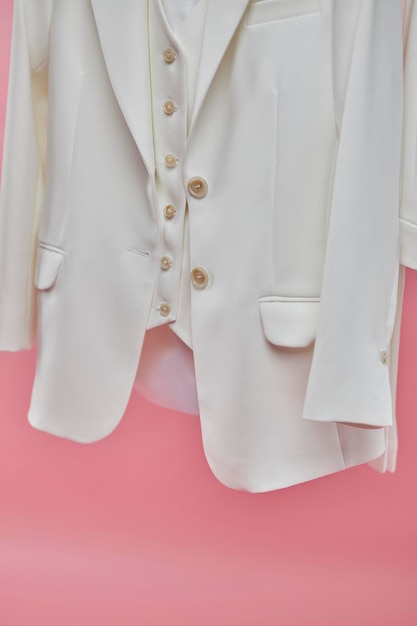 women's white suit on a pink background a woman in a white formal suit on a pink background