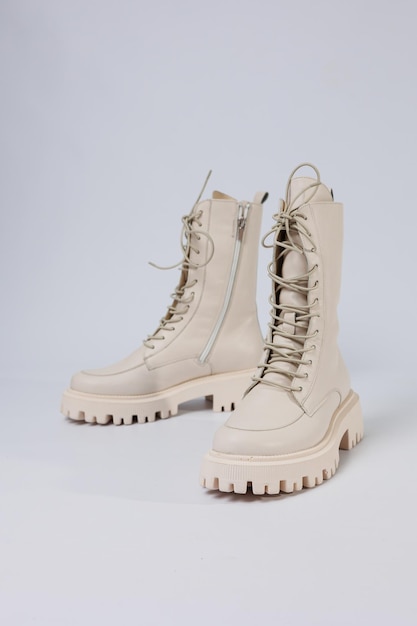 Women's white winter boots with fur with thick soles and laces. Advertising of the new collection of women's shoes 2022