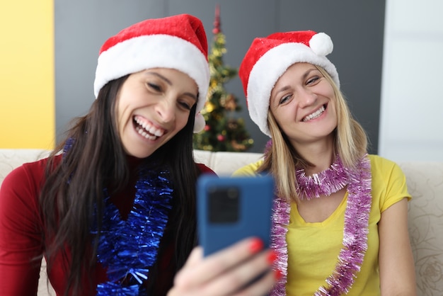 Women in Santa Claus hats with phone