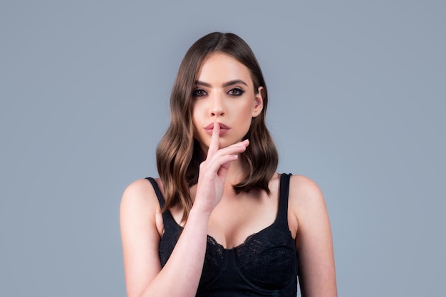 Women secrets woman showing secret sign female with finger in mouth closeup portrait of young woman