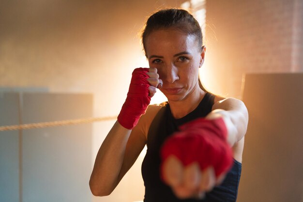 Photo women self defense girl power strong woman fighter punching with red boxing wraps sports protective