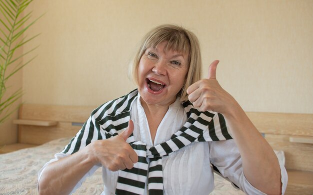 Donne senior che fanno azione funky capelli grigi donna, sorriso di mezza età vecchia donna a casa dentro, donna pensionata sola positiva felicità