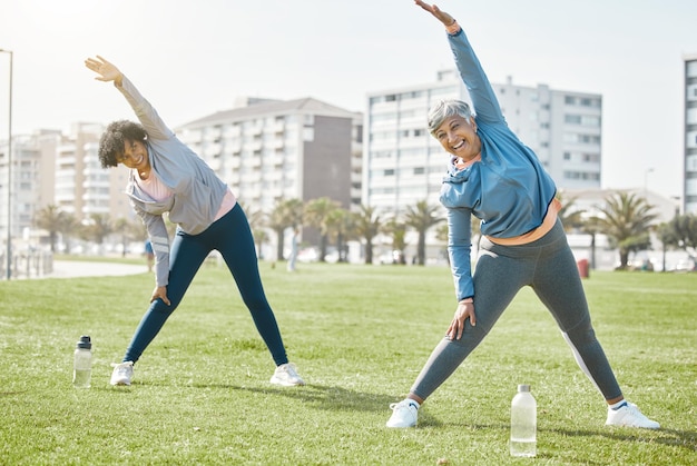 Women senior and stretching outdoor exercise and wellness with flexibility and start workout in park Female people friends with pilates or running in nature training and fitness with vitality