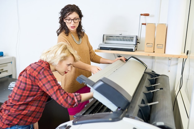 Photo women setting up plotter