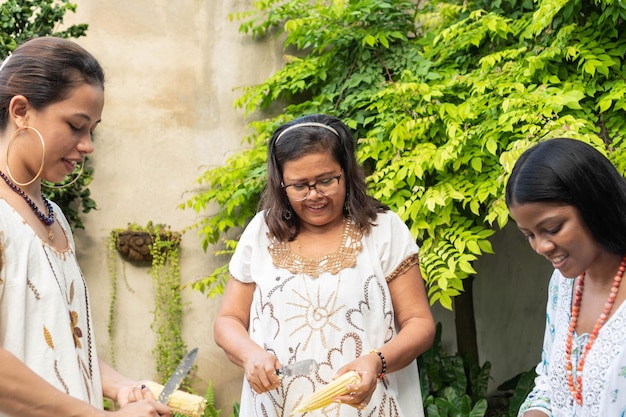 Women shelling corn for the family dinner