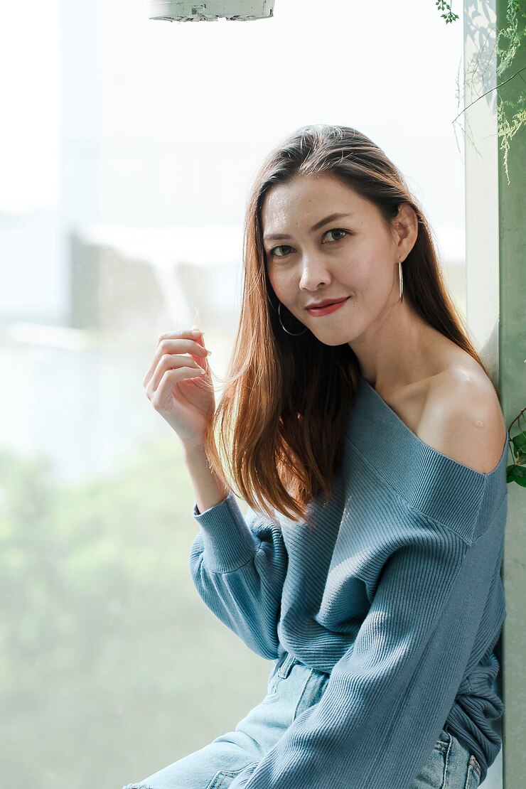 Photo 坐在玻璃窗旁的女人