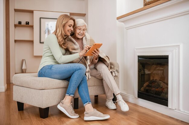 Women sitting on a comfortable sofa by the white fireplace