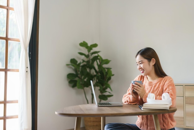 Women sitting on floor to drinking coffee and reading finance chart on laptop in lifestyle at home