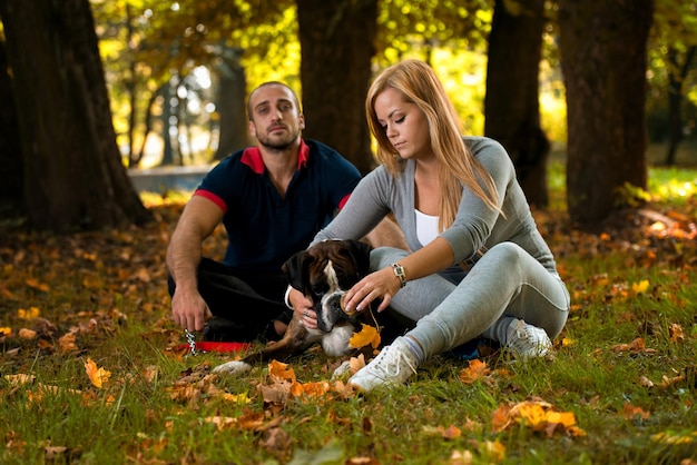 Donne che si siedono all'aperto con il suo pugile tedesco del cane da compagnia