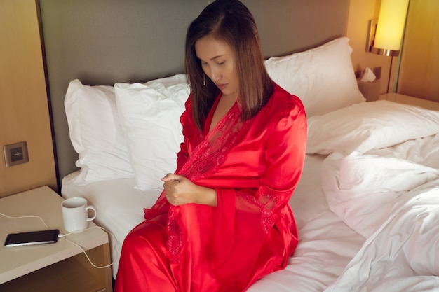 Women sitting in white beds start wearing nightgowns and long sleeve satin robes with floral lace