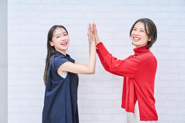 Women smiling and highfiving indoors