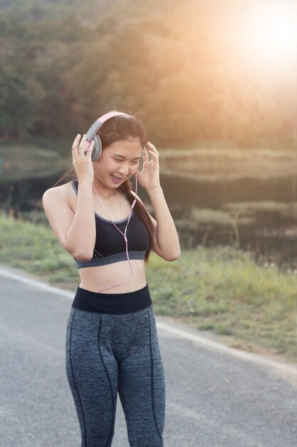 Women  in sportswear listening to music on headphone