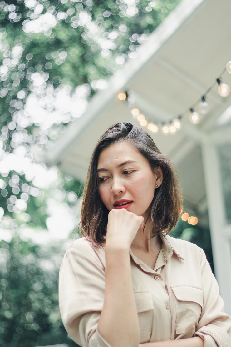 Photo 場所を飾るためにぶら下がっているライトの下に立っている女性