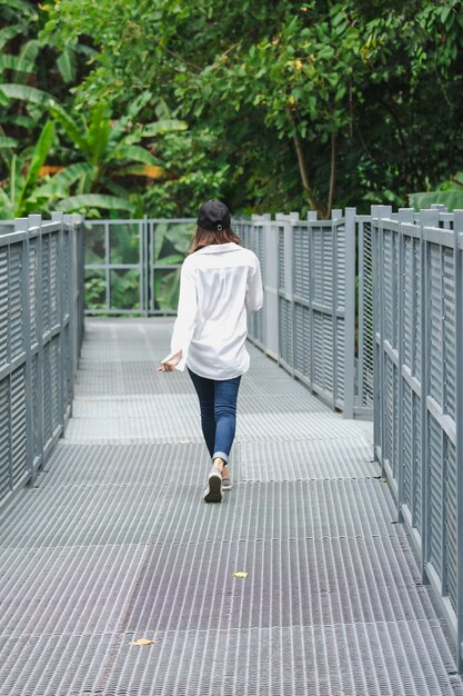 公園の鉄橋でポーズに立っている女性