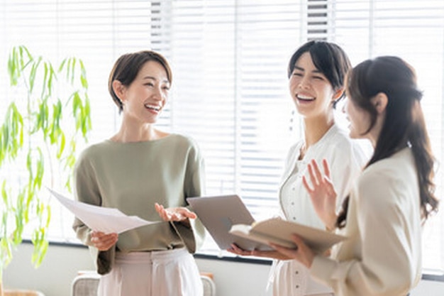 women talk with a group of women in a room