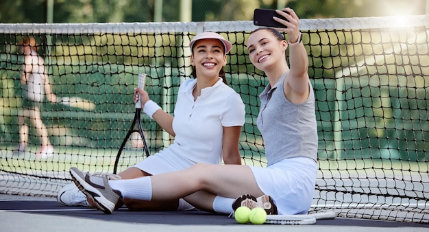여성 테니스 코트 또는 전화 셀카 피트니스 본딩 운동 휴식 또는 경기 또는 경쟁 스포츠 훈련 행복한 미소 테니스 선수 친구 또는 소셜 미디어 모바일 기술 사진