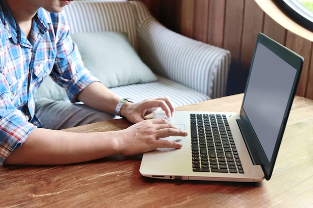 Computer portatile di battitura a macchina dello schermo e dell'uomo commovente delle donne sulla tavola di legno